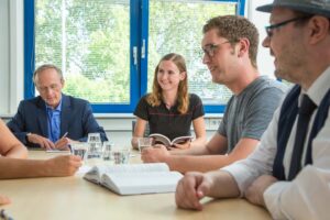 Teilnehmer der Weiterbildung an einem Tisch