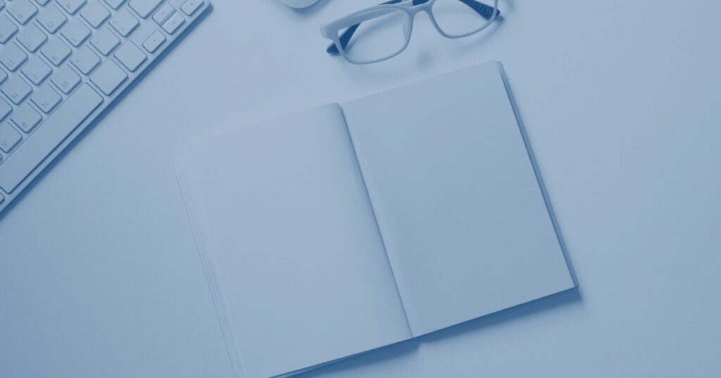 Arbeitsplatz von oben mit Notizbuch und Stift