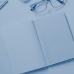 Arbeitsplatz von oben mit Notizbuch und Stift