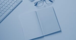Arbeitsplatz von oben mit Notizbuch und Stift